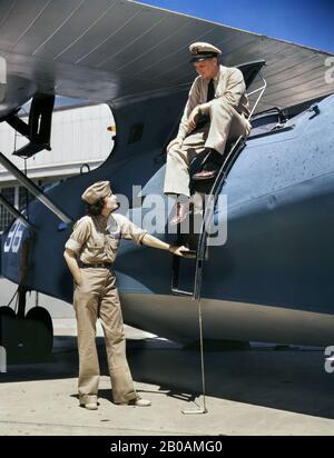 Frau Eloise J. Ellis, Senior Supervisor im Assembly and Repairs Department der Naval Air Base, Im Gespräch mit einem der Männer, Corpus Christi, Texas, USA, Foto von Howard R. Hollem, U.S. Office of war Information, August 1942 Stockfoto