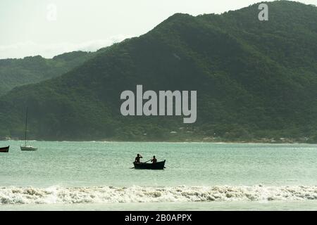 Silhouette eines Ruderbootes am Strand, am Strand Pantano do Sul, in Florianopolis, Brasilien. Stockfoto