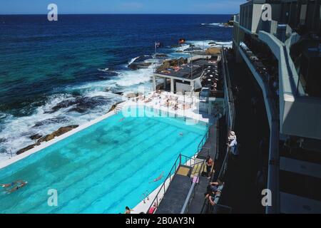 Schwimmer am berühmten Bondi Eisberge Ocean Pool, an einem sonnigen Tag mit klarem blauen Himmel und sonnigem Licht Stockfoto