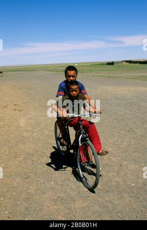 MONGOLIA, IN DER NÄHE VON DALANZADGAD, WÜSTE GOBI, DORF BULGAN, JUNGEN AUF DEM FAHRRAD Stockfoto