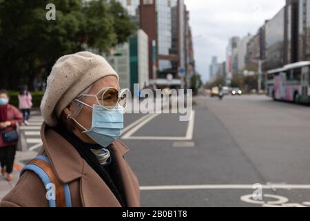 Taiwanerin auf der belebten Taipei Straße trägt Gesichtsmaske, um sich gegen die Kovid-19-Coronavirus-Epidemie zu schützen. Stockfoto