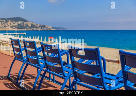 Mittelmeer und die berühmten Blauen chais an der Promenade des Anglais bei Sonnenuntergang in Nizza, Côte d'Azur, Frankreich Stockfoto