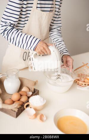 Mischen weiß ei Sahne in der Schüssel mit Motor Mixer, backen Kuchen Stockfoto