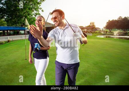 Ein glückliches Paar befindet sich auf einem Golfplatz. Stockfoto