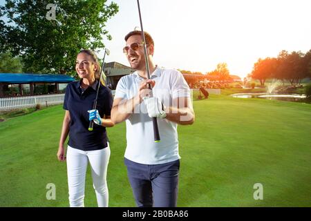 Ein Foto eines männlichen und weiblichen Golfspielers mit Schlägern in der Hand. Stockfoto