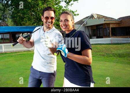 Ein paar glückliche Golfer sind auf einem Golfplatz. Stockfoto