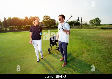 Ein attraktives Paar Golfer ist auf einem Golfplatz. Stockfoto