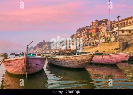 Varanasi, Indien - 11. November 2015. Am Fluss Ganges moorierte Holzboote, die für Rudertouristen und Hindu-Pilger entlang der am Wasser gelegenen Ghats verwendet werden. Stockfoto