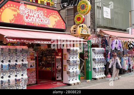 Frau, die an Geschäften in der Takeshita Street, Harajuku, Tokio, Japan vorbeiläuft Stockfoto