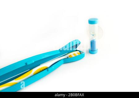 Zahnbürste in einem Kunststoffgehäuse und Zahnhourglas auf weißem Hintergrund Stockfoto