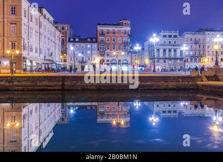 Triest - Dezember 2016, Italien: Nachtansicht von Triest, alte Gebäude Spiegel im Wasser spiegelt, Grand Canal in Triest Stadtzentrum Stockfoto