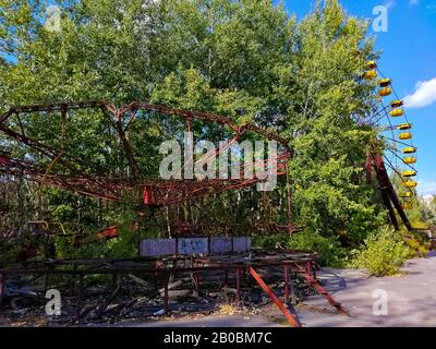 Riesenrad und Karussell im legendären verlassenen Vergnügungspark von Pripyat, Ukraine, Ort der Reaktorkatastrophe von Tschernobyl 1986. Stockfoto