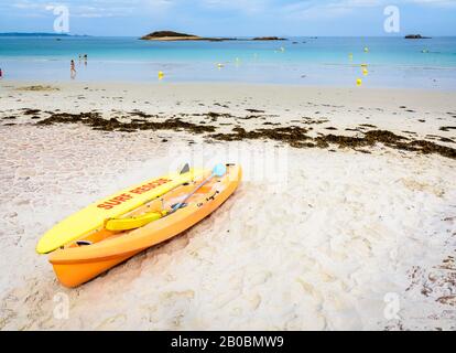 Rettungsschwimmer Gelber Rettungsschirm und See-Kajak an einem sandigen Strand in Penvenan, Nordbretagne, Frankreich. Stockfoto