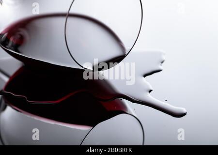 Glas Rotwein auf einem schwarzen reflektierenden Hintergrund. Selektiver Fokus. Stockfoto