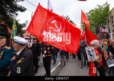 Anapa, Russland - 9. Mai 2019: Die rote Fahne der Kommunistischen Partei der Russischen Föderation unter den Teilnehmern der Siegesparade in Anapa Stockfoto