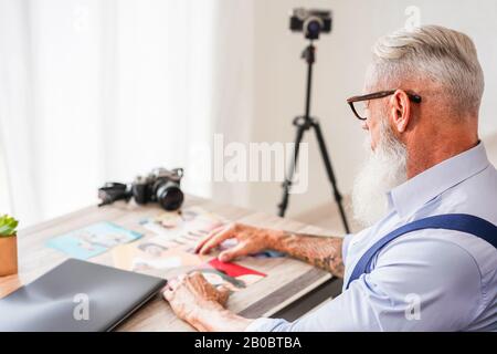 Trendfotograf in seinem Kreativstudio, der Fotos auswählt - Hiphster man at Work - Jobtrends, Mode, Schnitt und Technologiekonzept - Focus Stockfoto