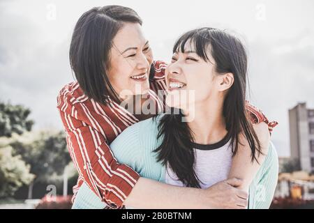 Asiatische Mutter und Tochter, die im Freien Spaß haben - Glückliche Familienmitglieder, die Zeit genießen, um die Stadt in Asien zu erkunden - Liebe, Elternschaft, Lebensstil, zärtliche Mutter Stockfoto