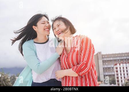 Asiatische Mutter und Tochter, die im Freien Spaß haben - Glückliche Familienmitglieder, die Zeit genießen, um die Stadt in Asien zu erkunden - Liebe, Elternschaft, Lebensstil, zärtliche Mutter