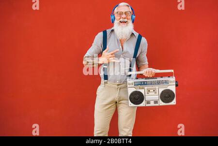 Fröhlicher Senior mit Boombox Stereo Musik hören - Trendiger reifer Kerl mit Spaß beim hören mit Vintage-Radio - Fröhliches älteres Lifestyle-Konzept - Lwl Stockfoto