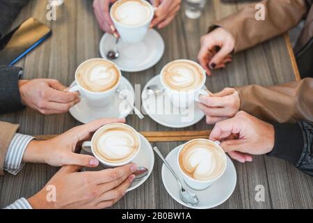 Die Leute sehen den Blick auf den Cappuccino in der Vintage Cafeteria Bar - Junge Freunde, die während der Wintersaison ein Frühstück machen - Kleben und Kaffee warm sein Stockfoto