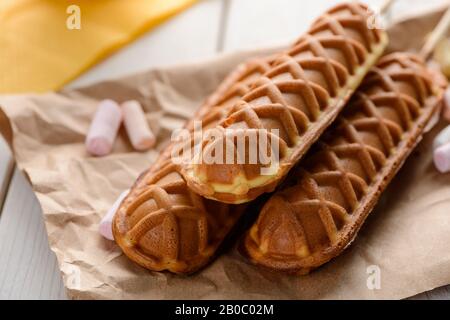 Schließen Sie drei Maishunde auf dem Verpackungspapier ab Stockfoto