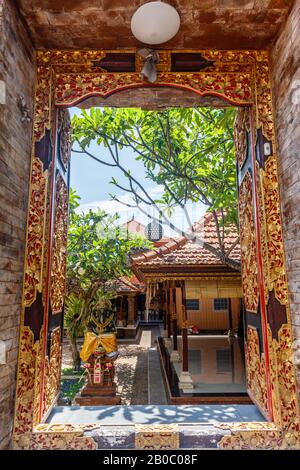 Hindutempel-Eingangstore mit Holztüren und Statuen. Canggu, Badung, Bali. Traditionelle balinesische Architektur. Bali, Indonesien. Stockfoto