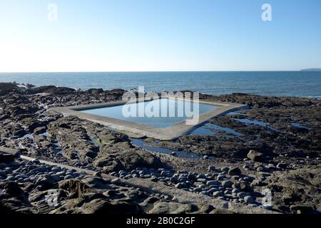 Schwimmbad mit quadratischem Rock über dem Strand bei Westward Ho! Auf dem South West Coastal Path, North Devon, England, Großbritannien. Stockfoto