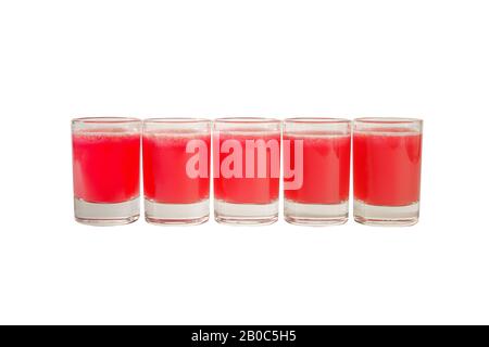 Rote, transparente Cocktails in gleicher Farbe, eine Reihe von Schüssen, fünf Portionen. Seitenansicht Isolierter weißer Hintergrund. Getränke für das Speiserestaurant, B. Stockfoto