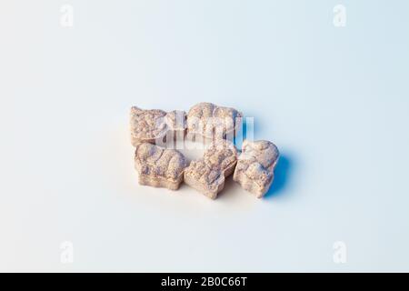 Vitamine von Kindern in Form von Tieren auf weißem Hintergrund mit hellblauer Farbe Stockfoto