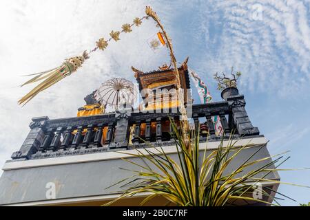 Sanggah Kemulan Rong, Familientempel auf dem Dach des traditionellen balinesischen Hauses. Penjor pfählen sich für Galungan-Feier. Bali, Indonesien. Stockfoto