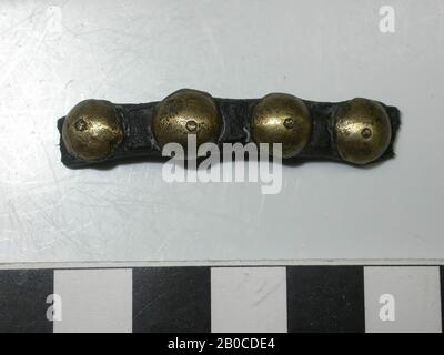 Fragment Lederriemen mit goldfarbenen (Kupferlegierung) Fittings. Der Batter besteht aus vier dekorativen Nägeln mit einer Kappe, konvex und rundlich in Form. Der Batter ist etwas breiter als das Band und ist in gleichen Abständen zueinander fixiert. Auf der Unterseite der Nägel befinden sich quadratische Zierplatten. Der Durchmesser des Schlagbattens beträgt 0,9 cm und die Dicke 0,4 cm. Die Abmessungen der Schlichtplatte betragen 0,3 x 0,4 cm. Der Durchmesser der Nägel beträgt 0,1 cm, Band mit Armaturen, organisch, Leder, Metall, Kupferlegierung, Band: L: 4,5 cm, W: 0,75 cm, D: 0,3 cm, Ende 14. Jahrhundert 1350 - 1400, Niederlande Stockfoto