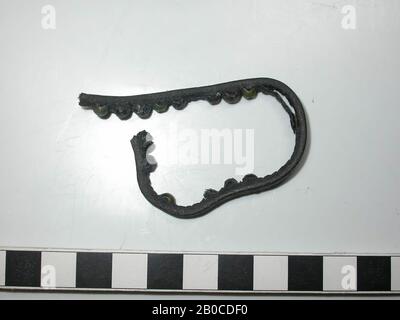 Fragment Lederriemen mit Fittings (Kupferlegierung). Am Band sind 14 runde und abgerundete Stollen mit einem Bleinagel befestigt. Am Gürtel fehlen etwa 13 Kappen, von denen nur die Löcher im Leder zu sehen sind. Die Farbe des Schlagbattens ist wegen der Korrosion des Bleis dunkelgrau bis schwarz. Zwischen den Kappen und den Fittings ist kein Raum so breit wie das Leder. Die Dicke des Bandes mit dem Batter beträgt 0,6 cm. Der Durchmesser des Schlagbattens beträgt 0,45 cm, die Dicke des Schlagbattens 0,3 cm. Der Durchmesser des Nagels beträgt 0,15 cm, Der Gürtel mit Armaturen, organisch, Leder, Metall, Kupferlegierung und Stockfoto