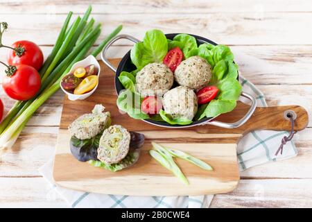 Diätetische Häckselchen, die im Ofen mit Brokkoli zubereitet werden und mit einer Rissohle serviert werden. Auf altem weißen Holzhintergrund. Stockfoto