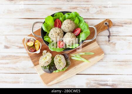 Diätetische Häckselchen, die im Ofen mit Brokkoli zubereitet werden und mit einer Rissohle serviert werden. Auf altem weißen Holzhintergrund. Stockfoto