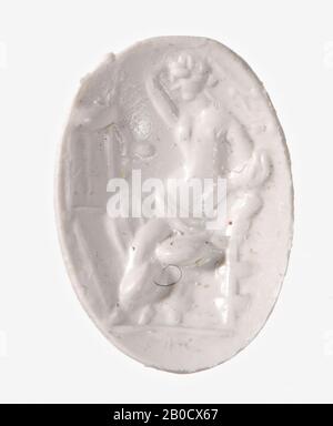 VZ: Der gott trägt einen Himation um seine Beine und den rechten Arm, sein linker Arm ruht auf seinem Kopf, sein rechter Arm auf dem Rücken seines Throns, sein Kopf ist im Profil und sein Körper in dreiviertel Vorderansicht dargestellt. Sein Haar ist lang und in einer Rolle im Hals verknotet, für den gott ein Stativ auf einem hohen Sockel., GEM, Intaglio, Ringstein, Plasma, Farbe: Grüne dunkle Sprenkel, Form: Oval, Bearbeitung: Vorder- und Rückseite konvex, Methode: Modellierung mit dicken und dünnen abgerundeten Radnuten, mit Details mit dünnen Radnuten, 11 x 9 mm, D. 2 mm, AD aus dem 1. Jahrhundert. 1-100 AD Stockfoto