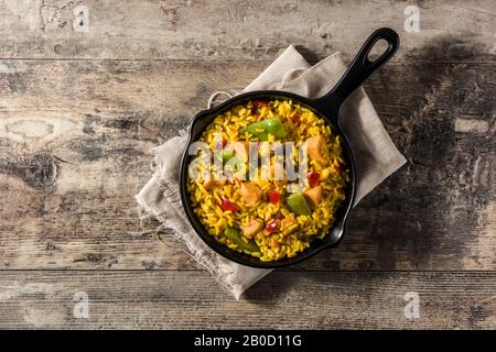 Gebratener Reis mit Huhn und Gemüse auf der Bratpfanne. Draufsicht Stockfoto