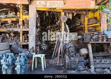 Iloilo City, Philippinen: Nahaufnahme einer Schrott- und Reparaturwerkstatt mit gebrauchten rostigen und öligen Motorteilen, Rädern und Wasserpumpen Stockfoto