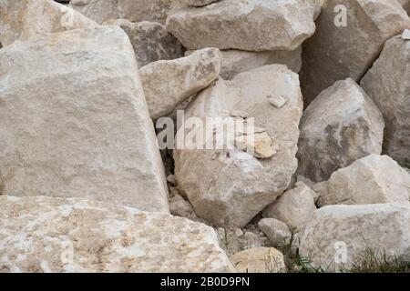 Haufen großer Sand Steine auf dem Boden der Baustelle. Stockfoto