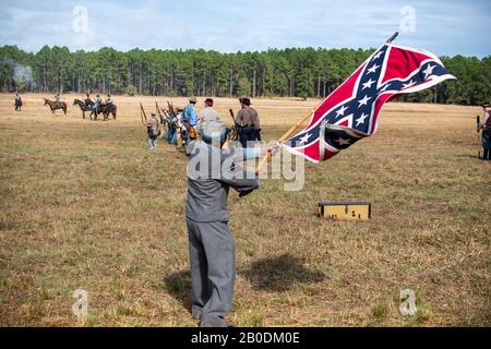 Brooksville, FL - 19. Januar 2020: Ein afroamerikanischer Bürgerkriegsreenactor wackelt eine große konfföderierte Flagge bei der Nachstellung des Brooksville Raid, Stockfoto