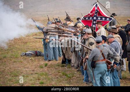 Brooksville, FL - 19. Januar 2020: Eine konfföderative Flagge überfliegt eine Gruppe von Reenactors, während sie den Feind anfeuern Stockfoto