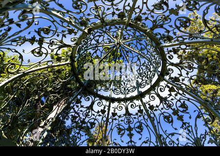 Schmiedeeisernes Gartenlaubendach im Park an einem sonnigen Tag Stockfoto