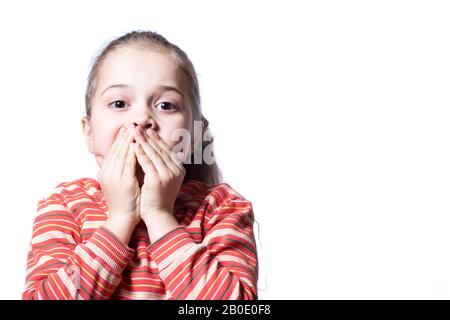 Das Mädchen bedeckte ihren Mund mit den Händen, das Baby unter Schock. Kind ist schockiert über das Bild auf weißem Hintergrund mit Kopierbereich. Stockfoto