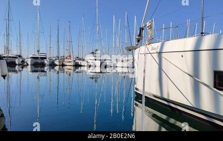 Athen, Griechenland. Februar 2020. Verankerte Yachten mit Masten in Alimos Marina, dem größten auf dem Balkan. Weiße Gefäße im Gegensatz zu blauem, ruhigem Meer. Ref Stockfoto