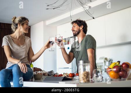 Paar, toasten Wein Gläser in Küche Stockfoto