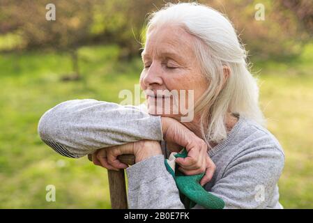 Ältere Frau im Garten entspannen Stockfoto