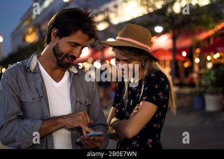 Junges Paar mit Smartphone auf der Straße Stockfoto