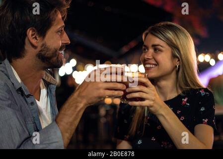 Ein junges Paar rösten im Café im Freien Cocktailgläser Stockfoto