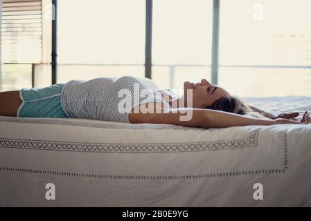 Frau auf Bett liegend Stockfoto