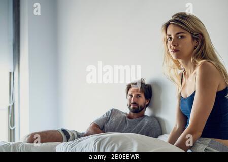 Junges Paar sitzt auf Bett Stockfoto