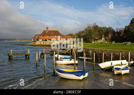 Haus am Ufer von Bosham im Chichester Harbour, West Sussex, England. Mit kleinen Booten gefestt. Stockfoto